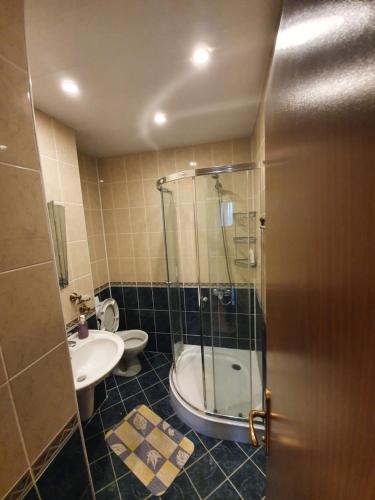 a bathroom with a shower and a toilet and a sink at Eli 2 Sea View apartment first line in Nesebar
