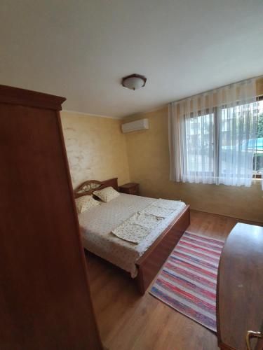 a bedroom with a bed and a window and a rug at Eli 2 Sea View apartment first line in Nesebar