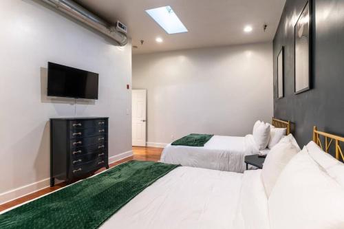 a bedroom with two beds and a flat screen tv at Jolene's Hideout - Noise Notice Wed-Sun in Knoxville