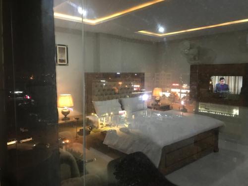 a bedroom with a large bed and a living room at Mukhtar Homes Bahria Town Lahore in Lahore