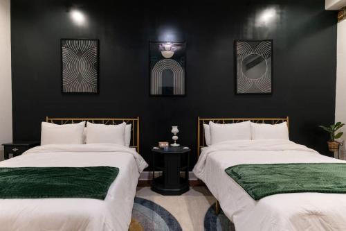 two beds in a room with black walls at Jolene's Hideout - Noise Notice Wed-Sun in Knoxville
