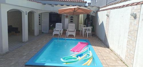 Πισίνα στο ή κοντά στο "Excelente Casa Pé na Areia com Piscina, Ampla Área de Lazer com Espaço Gourmet Externo, Deck Coberto com Churrasqueira e Cooktop, Cozinha Americana, Ampla Sala de Estar com Lindíssima Lareira, Smart TV 50", Wi-Fi e o Principal é muito Pertinho da Praia"