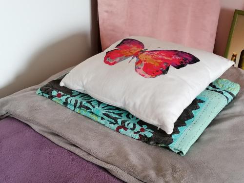 almohada de mariposa sobre una cama en LOU GRAOU CHEPRE gîte d'étape en Chandon
