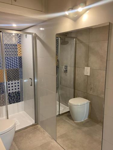 uma casa de banho com uma cabina de duche em vidro e um WC. em Porta Romana Cozy Studio em Milão