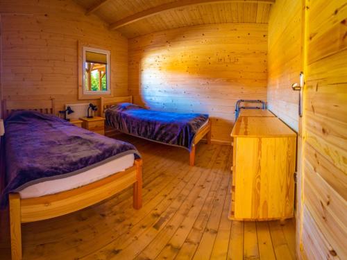 a bedroom with two beds in a wooden cabin at Bogdanka Park in Trzebin