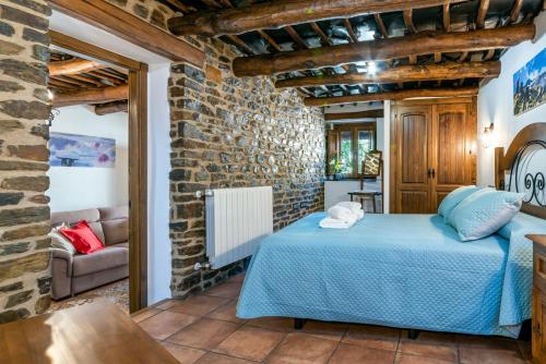 1 dormitorio con 1 cama azul en una pared de ladrillo en Casa Antonia Capileira La Alpujarra en Capileira