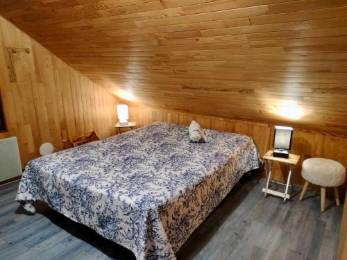 - une chambre avec un lit et un chat assis dans l'établissement Chalet à proximité de l'Ubaye, à Jausiers