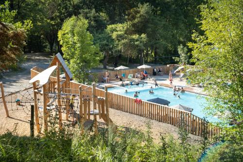 une grande piscine avec des gens qui y jouent dans l'établissement Huttopia Lac de Serre-Ponçon, à Le Lautaret