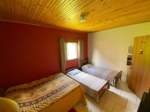 een slaapkamer met 2 bedden en een raam erin bij Pousada Arco Iris in Gonçalves