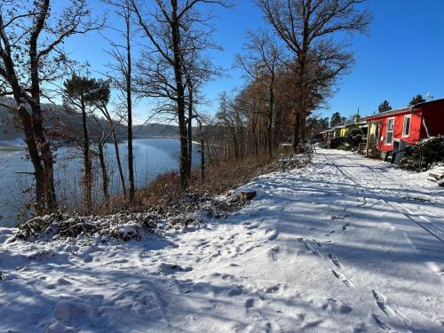 a snow covered road next to a body of water at Ferienhaus Zeulenrodaer Meer in Stelzendorf