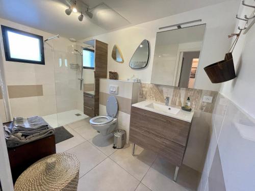 La salle de bains est pourvue de toilettes, d'un lavabo et d'une douche. dans l'établissement le verger des naiades, au Lavandou