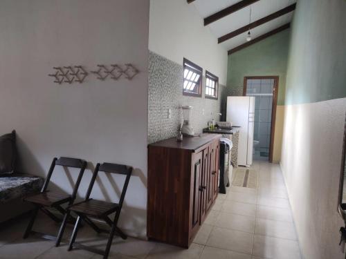 a kitchen with two chairs and a table and a refrigerator at Trindade Hospeda - Estúdios e Casa Vila Trindade in Trindade