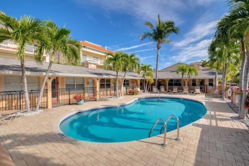 a swimming pool in front of a resort with palm trees at Walk to the Beach and Restaurants! - Coconut Villa's Suite 2 in St Pete Beach