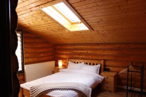 - une chambre avec un lit dans une cabane en bois dans l'établissement Pensiunea Mara, à Mintiu