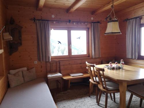 uma sala de jantar em madeira com uma mesa e uma janela em Walters Hütte em Tulfes