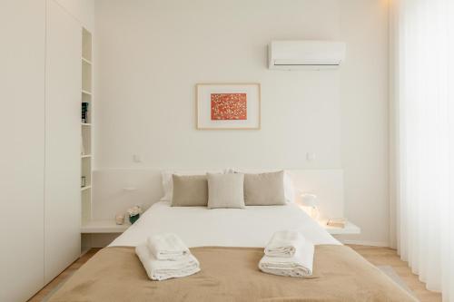 - une chambre blanche avec un lit et 2 serviettes dans l'établissement Boavista Collection Apartment - Minho's Guest, à Braga