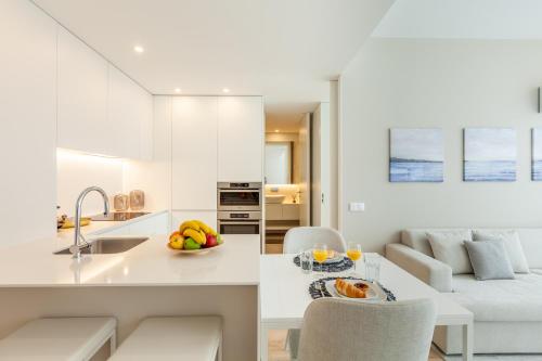 a kitchen and living room with a table and chairs at Boavista Collection Ap for Family by Sé Apartamentos in Braga