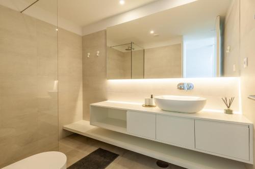 a white bathroom with a sink and a mirror at Boavista Collection Apartment by Sé Apartamentos in Braga