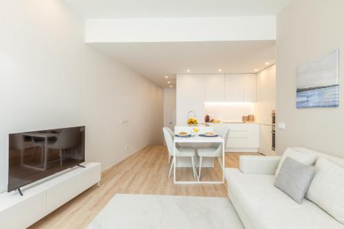 a white living room with a white couch and a table at Boavista Collection Ap for Family by Sé Apartamentos in Braga