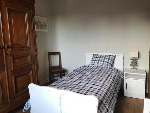 a bedroom with a bed with a checkered blanket at Les colombages in Dinant