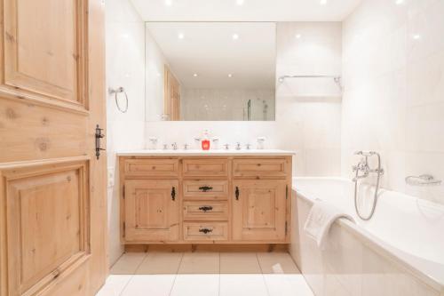 a bathroom with a tub and a sink and a mirror at St Moritz 3 Suite vista lago in St. Moritz