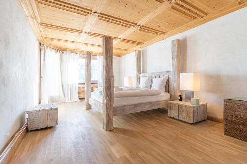 a bedroom with a bed with a wooden ceiling at St Moritz 3 Suite vista lago in St. Moritz