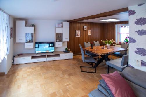 a living room with a dining table and a television at Ferienhaus Nepomuk in Lauterecken