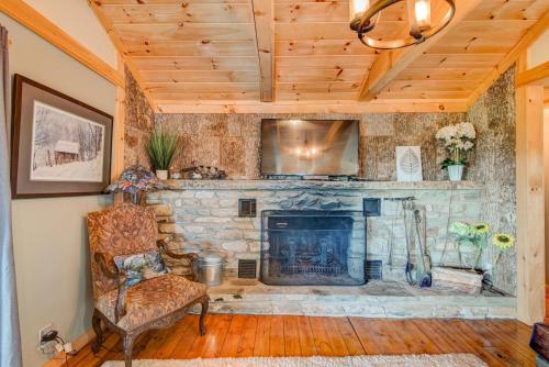 a stone fireplace in a living room with a chair at Crystal View in Valle Crucis
