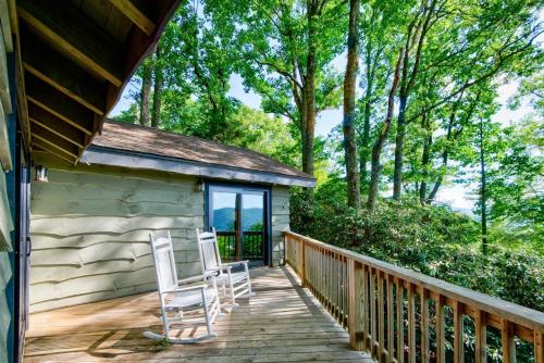 a deck with two chairs and a house at Crystal View in Valle Crucis