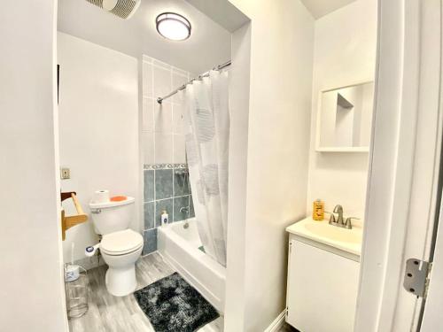 Baño blanco con aseo y lavamanos en Sweet House 18mins To DTLA 2 bedrooms, en Rosemead