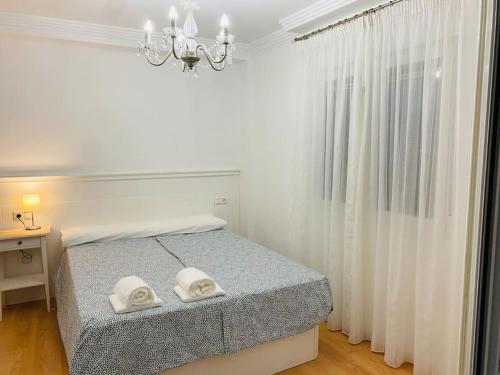a bedroom with a bed with two white towels on it at Apartamento centro de Granada 2 in Granada