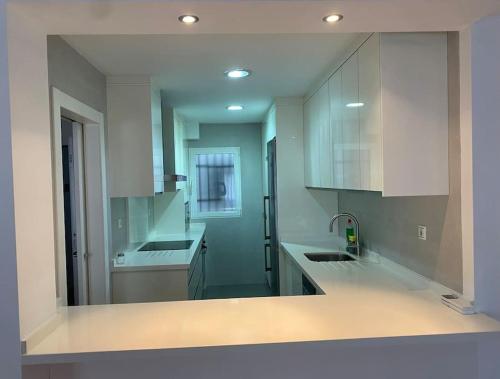 a kitchen with white cabinets and a sink at Apartamento centro de Granada 2 in Granada