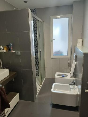 y baño con aseo, lavabo y ducha. en Habitación privada en casa particular en Albacete