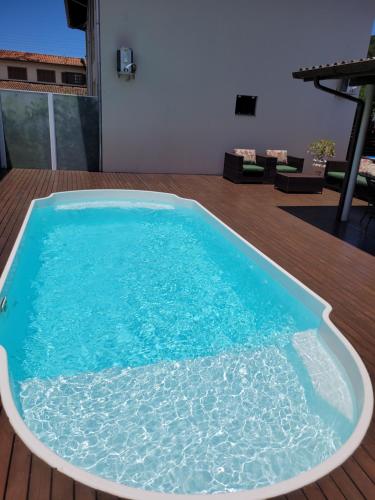 una grande piscina d'acqua su una terrazza di legno di Aptos do Angelo a Pinheira
