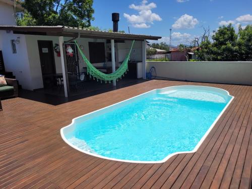 - une piscine sur une terrasse avec un hamac dans l'établissement Aptos do Angelo, à Pinheira