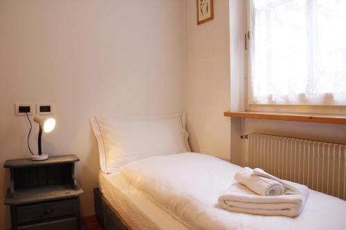 um pequeno quarto com uma cama com toalhas em Ciasa Buro - Coba em Moena