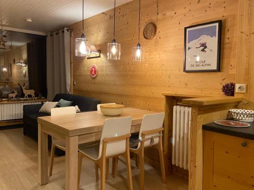 une salle à manger avec une table et des chaises en bois dans l'établissement Appartement cosy au pied des pistes, à La Clusaz