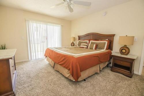 een slaapkamer met een groot bed en een plafondventilator bij Royal Palm Bay 3 Bedroom Condo Resort Pool 10 Min Disney in Kissimmee