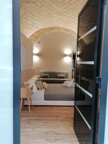 a bedroom with a bed in a room with a mirror at La Dimora del Principe-Piano terra in Trani