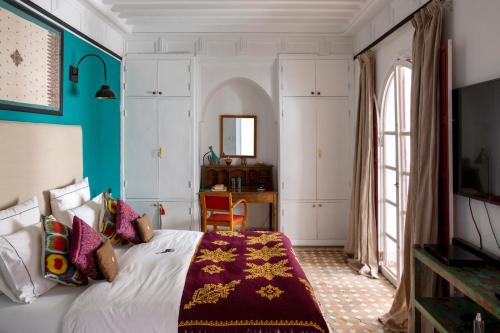 una camera da letto con un letto e una scrivania di Indian Palace a Marrakech