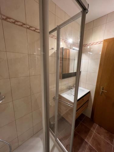 a glass shower in a bathroom with a sink at Gästehaus Wallner in Presseggen