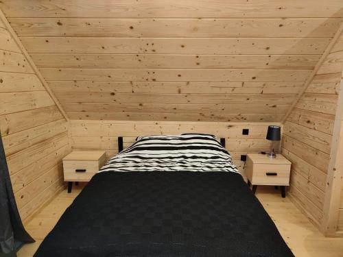 a bedroom with a bed in a wooden room at beskid house in Spytkowice