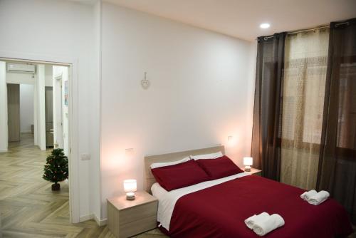 a bedroom with a red bed and a christmas tree at Salifornia casa vacanze in Salerno
