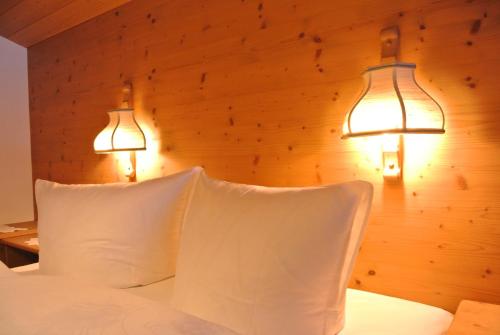 a bedroom with two lamps and a bed with white pillows at Haus Christopherus in Klösterle am Arlberg