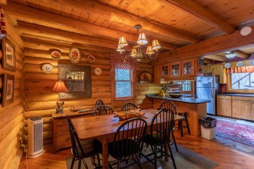 a dining room and kitchen in a log cabin at Draggin Fly in Valle Crucis