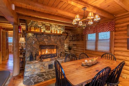 a dining room with a wooden table and a fireplace at Draggin Fly in Valle Crucis