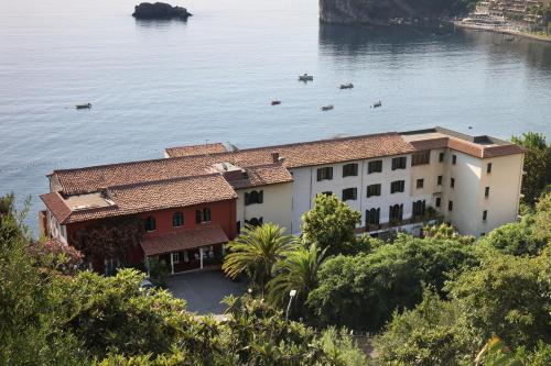un edificio junto al agua con barcos dentro en Hotel Lido Mediterranee, en Taormina