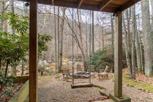 a porch with a swing in the woods at Draggin Fly in Valle Crucis