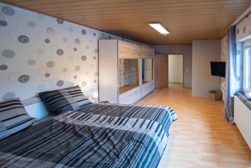 a bedroom with two beds and a tv on a wall at Ferienhaus Nepomuk in Lauterecken