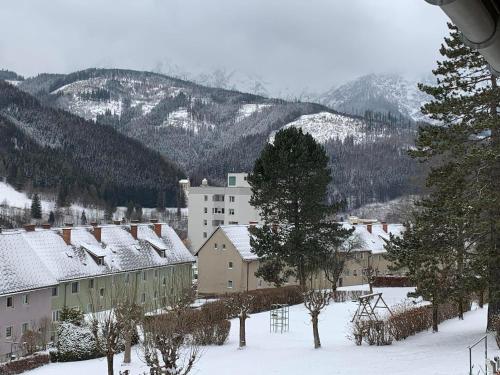 a town in the snow with mountains in the background at Eisenerzer Apartmenthaus in Eisenerz